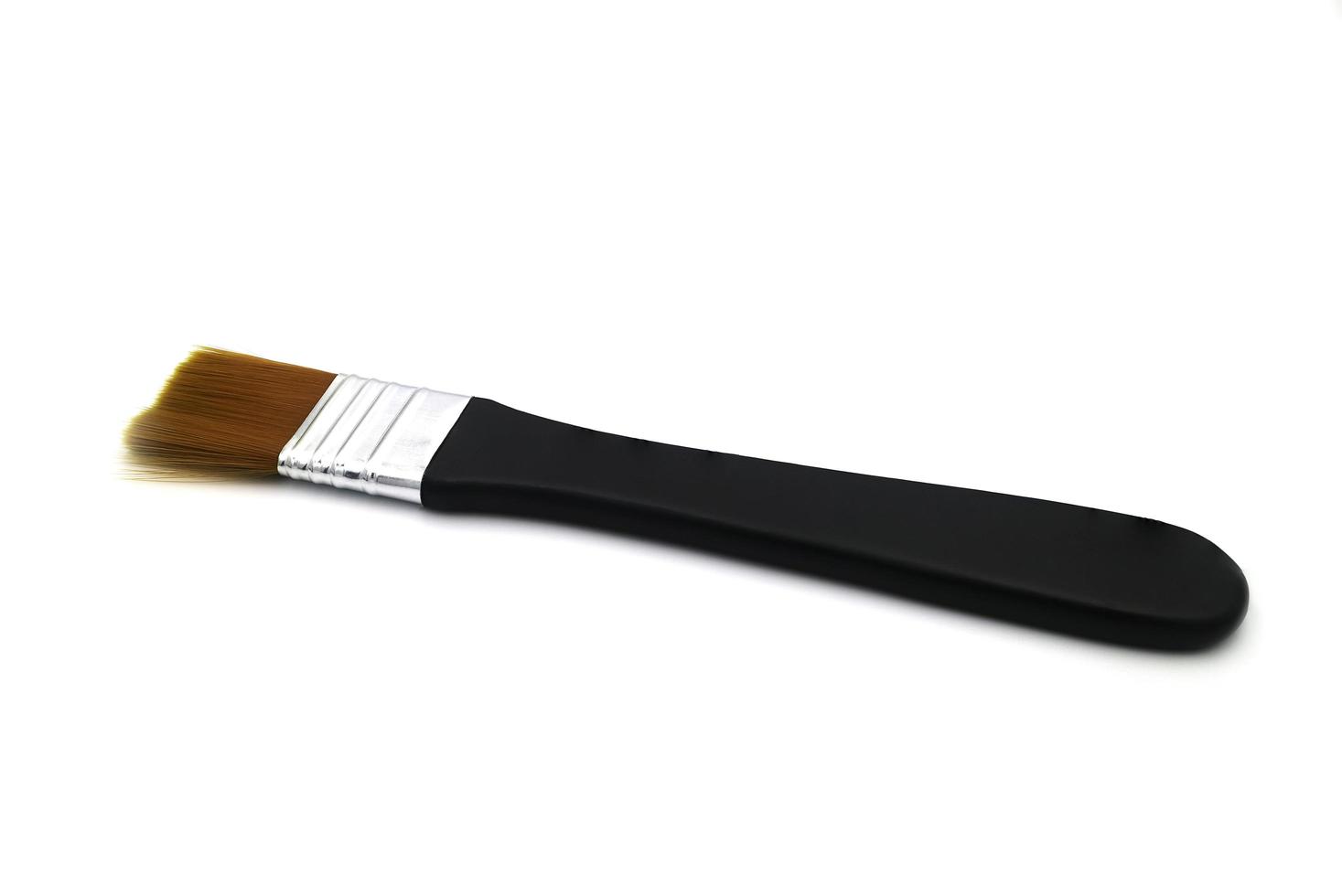 Black paintbrush isolated on a white background. photo