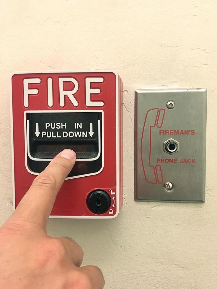 Closeup Shot of button switch fire,Fire alarm box on cement wall for warning and security system. photo