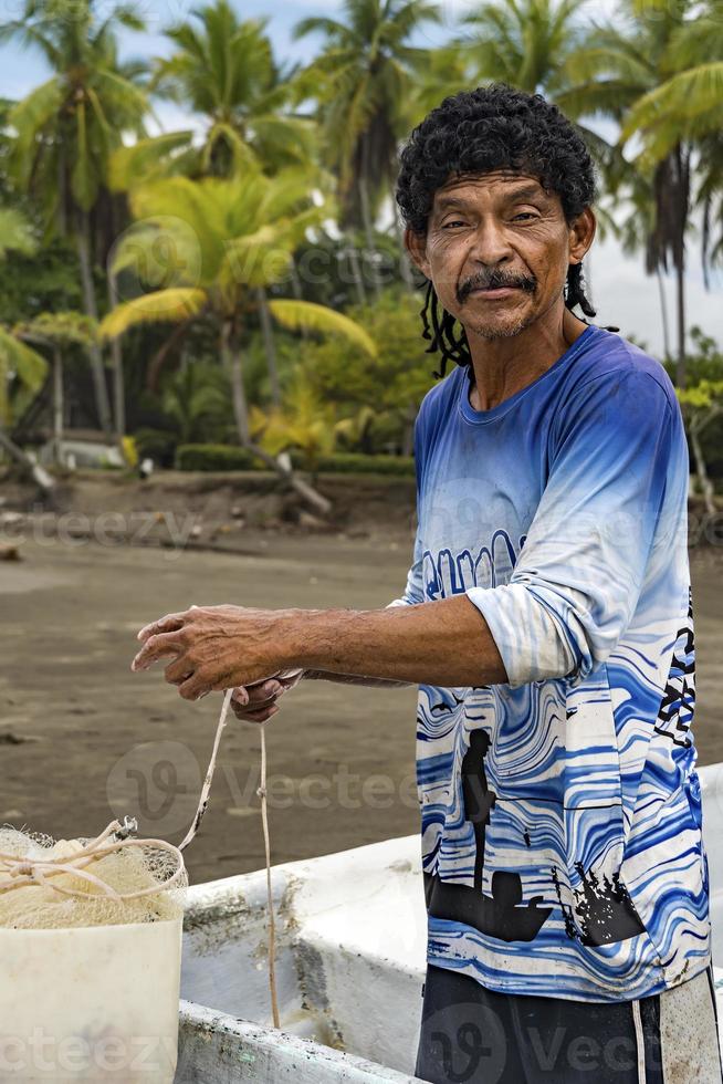 Man looking at the camera preparing his net for fishing. photo