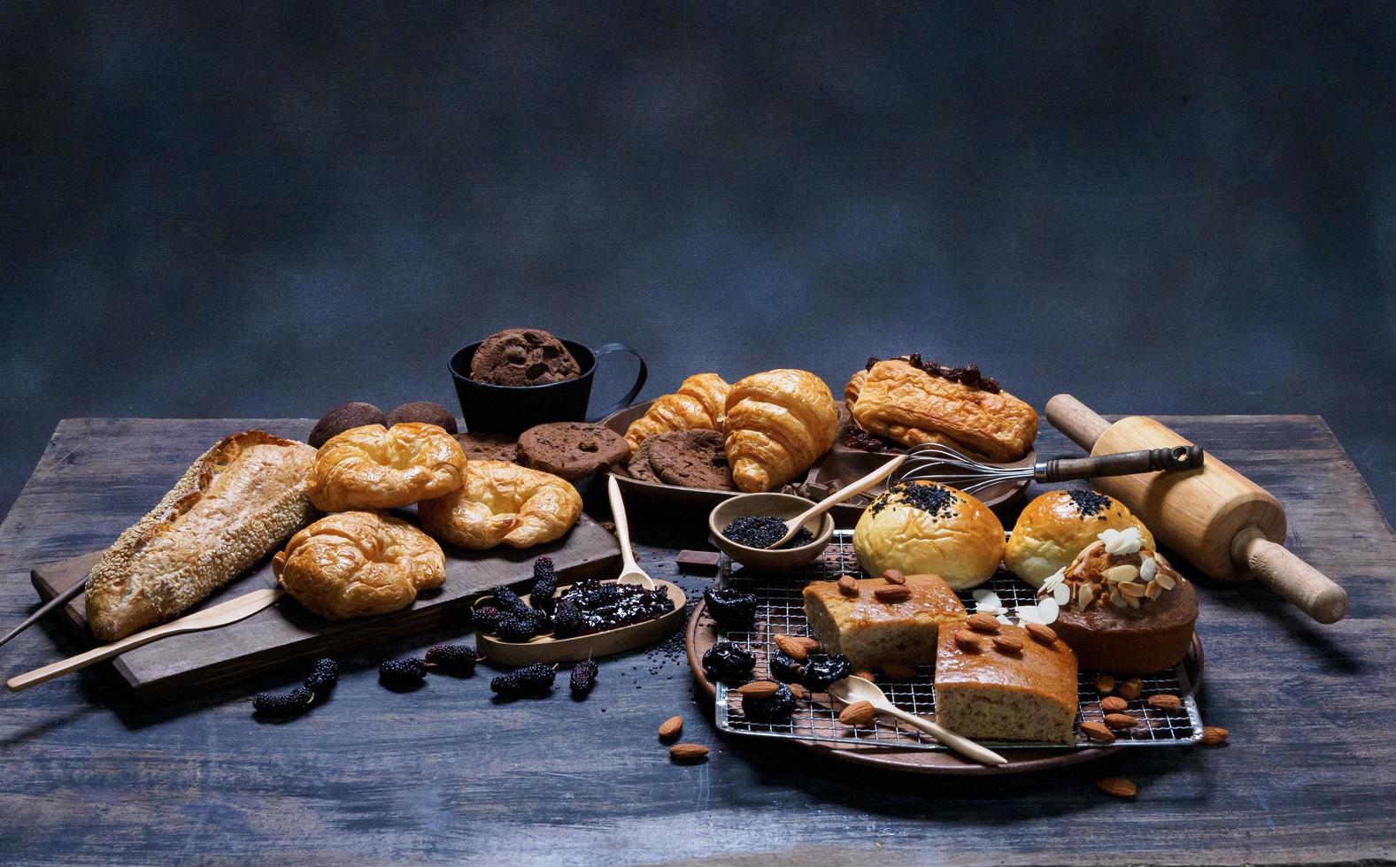 vista superior pan fresco pasas marrón panadería de sésamo hecha de harina de trigo comida casera adecuada para una alimentación saludable en el piso de la mesa de madera fondo oscuro rústico negro foto