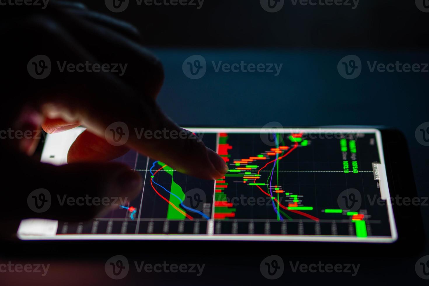 hombre toca el gráfico de velas del mercado de valores en el teléfono inteligente foto