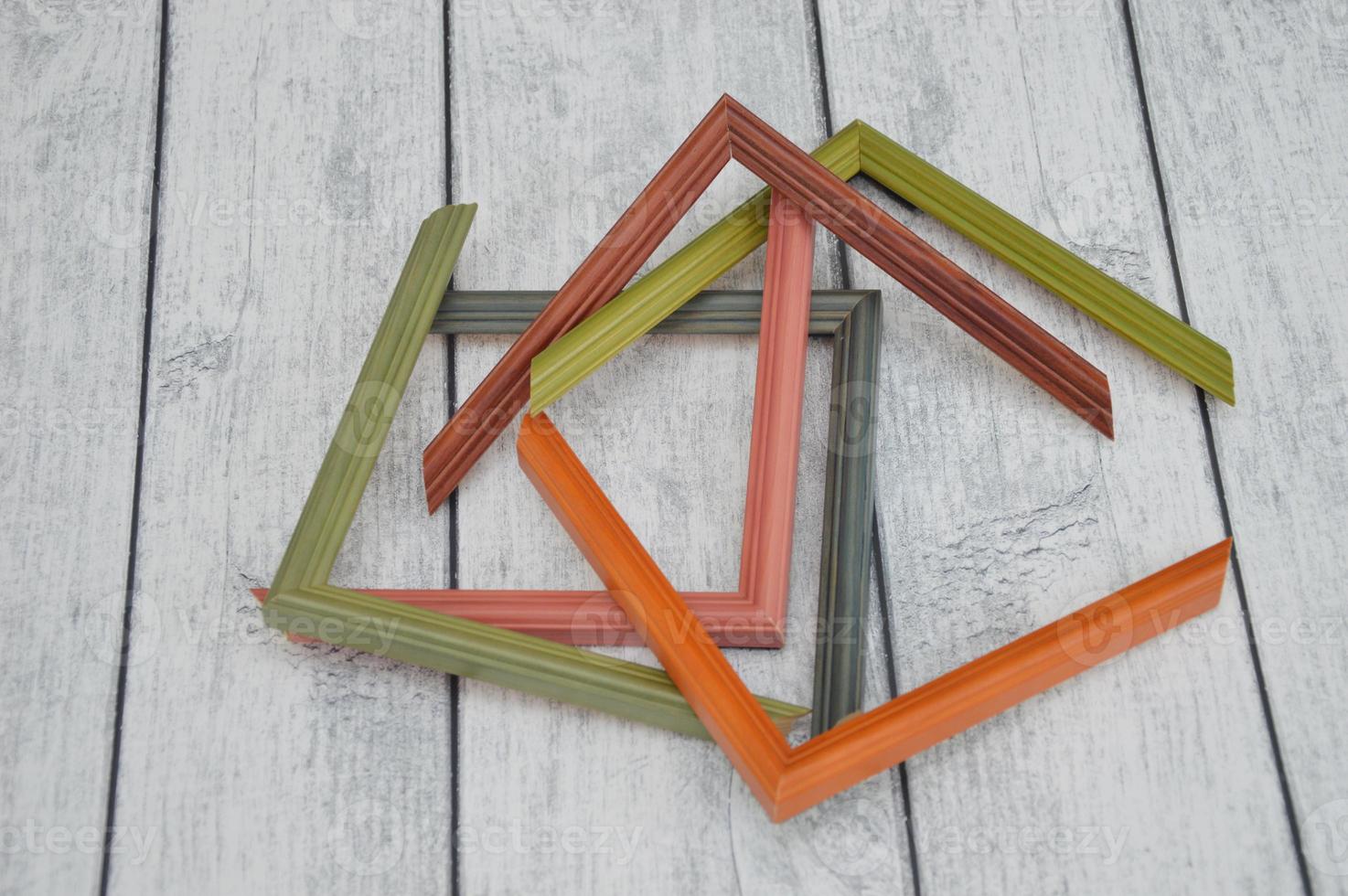 Decorative modern colored picture frames. Patterns of frames for a baguette, lying on a wooden background. Workshop photo