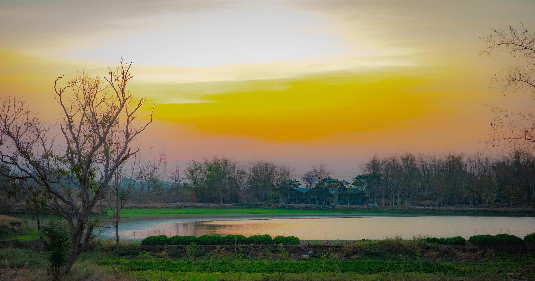 a small lake in the middle of a village settlement in the late afternoon photo