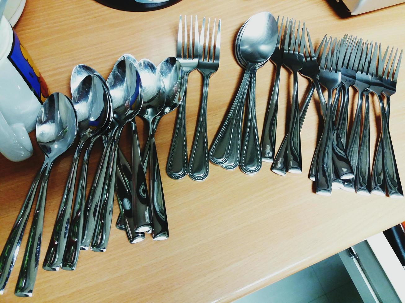 Many spoon and fork on the wooden table at kitchen room photo