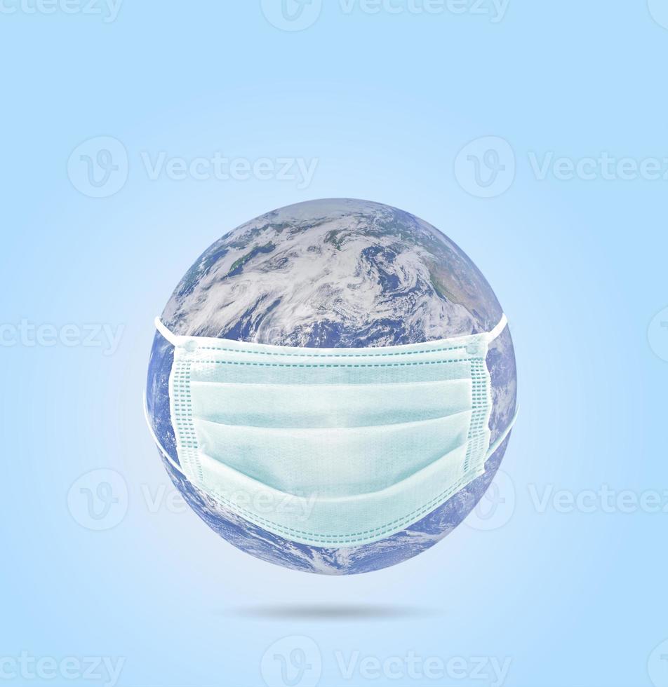 On planet earth, a medical mask to protect against the coronavirus epidemic. Concept of a global virus epidemic, concept of Corona virus quarantine. photo