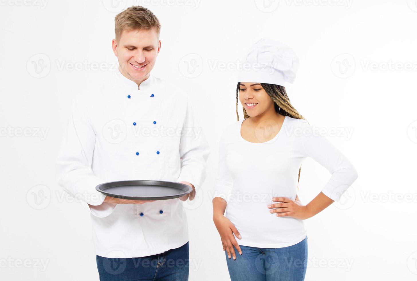 Male and female cooks in uniform hold empty tray isolated on white background photo