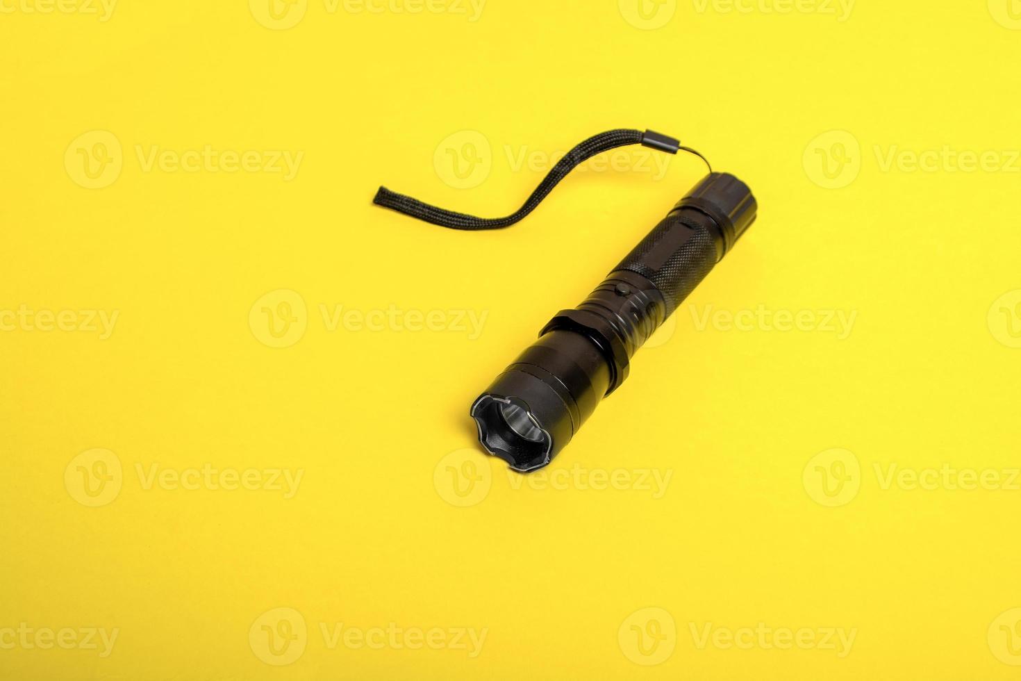 black flashlight shocker on a yellow background photo