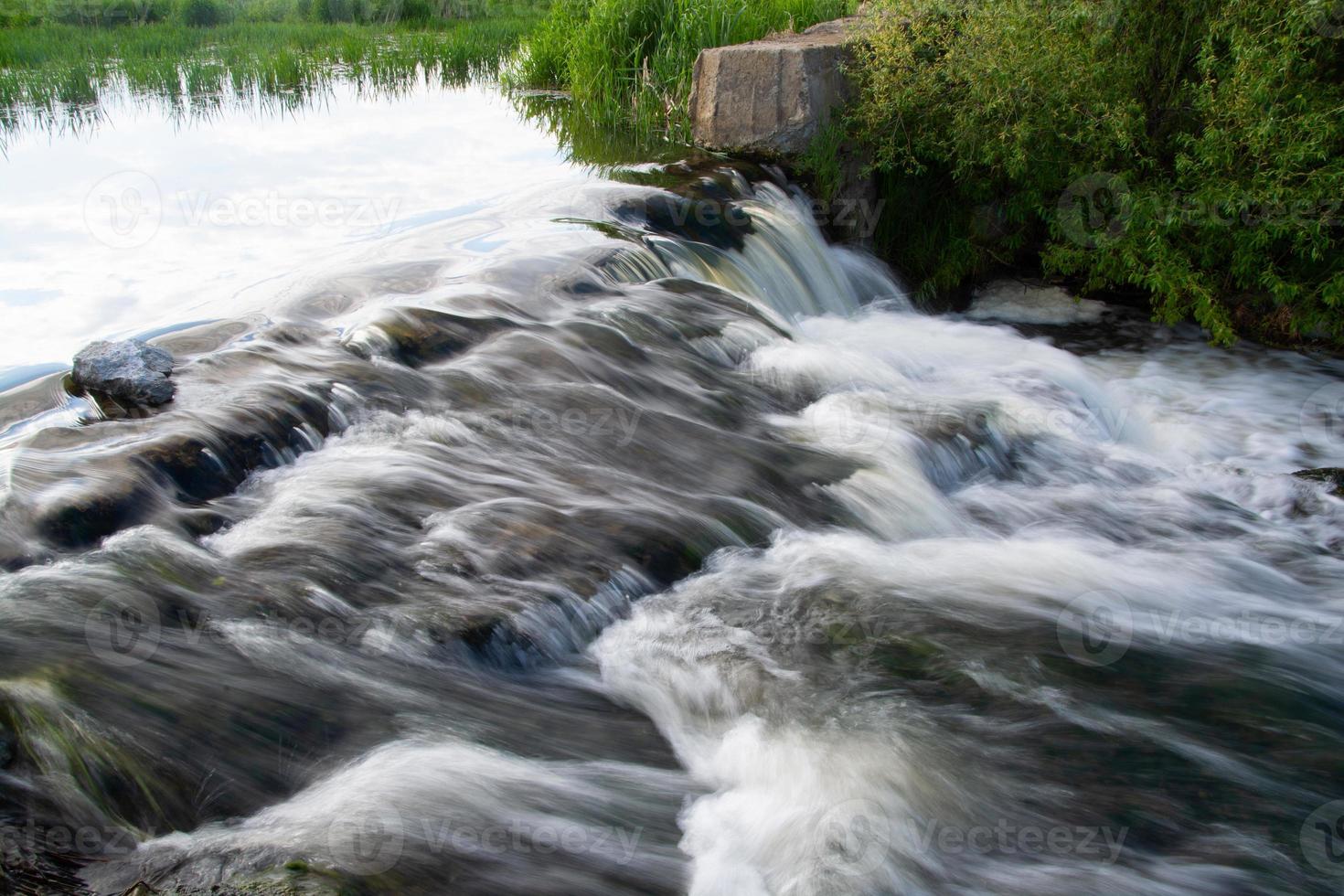 a small river waterfall on a bright sunny summer day. photo