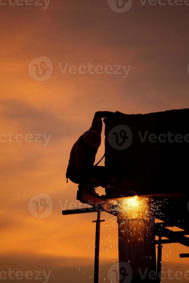 Silhouettes of worker welder photo