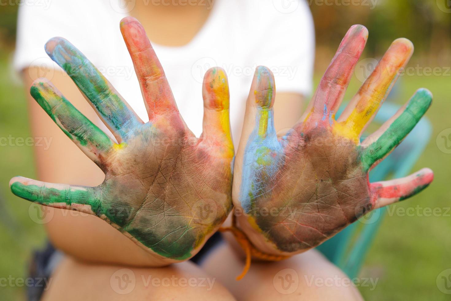 Asian little girl with hands painted in colorful paints photo