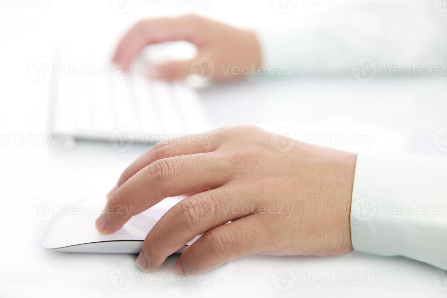 Hand using mouse and computer keyboard photo