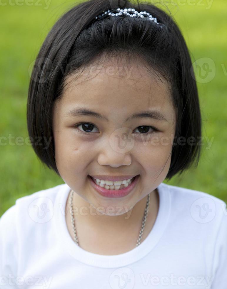 chica asiática relajarse y sonreír felizmente en el parque foto