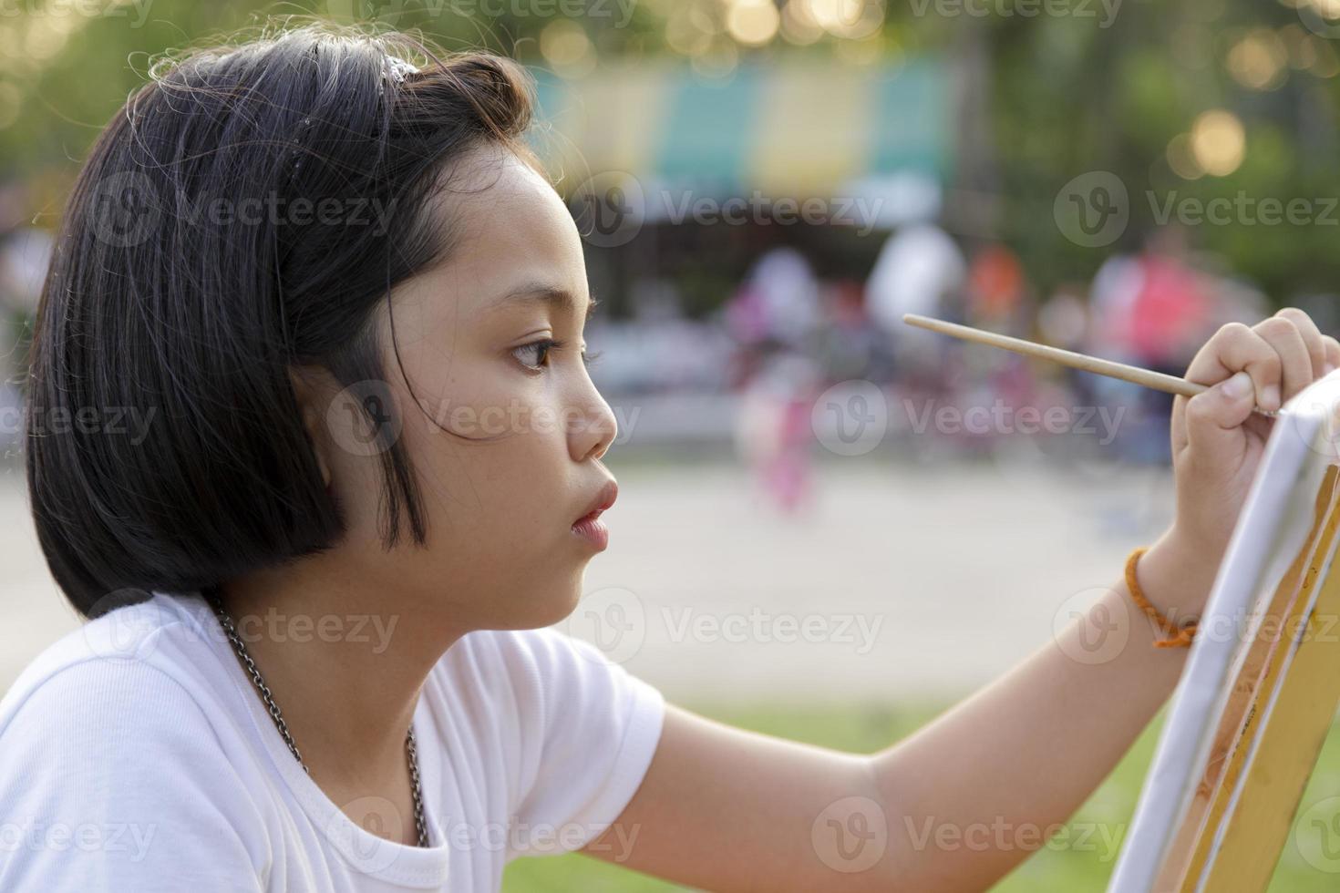 niña asiática pintando en el parque foto