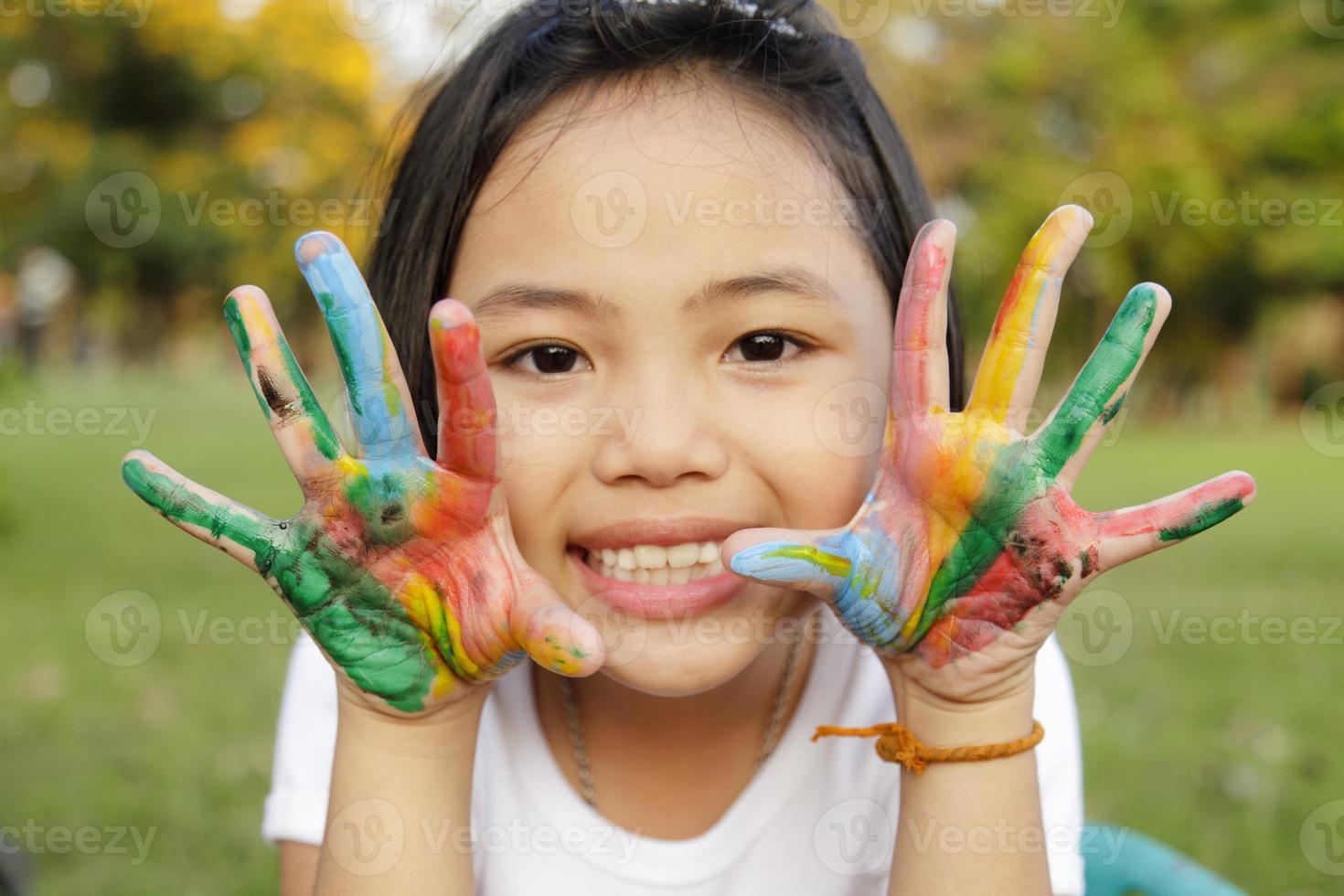 Asian little girl with hands painted in colorful paints photo