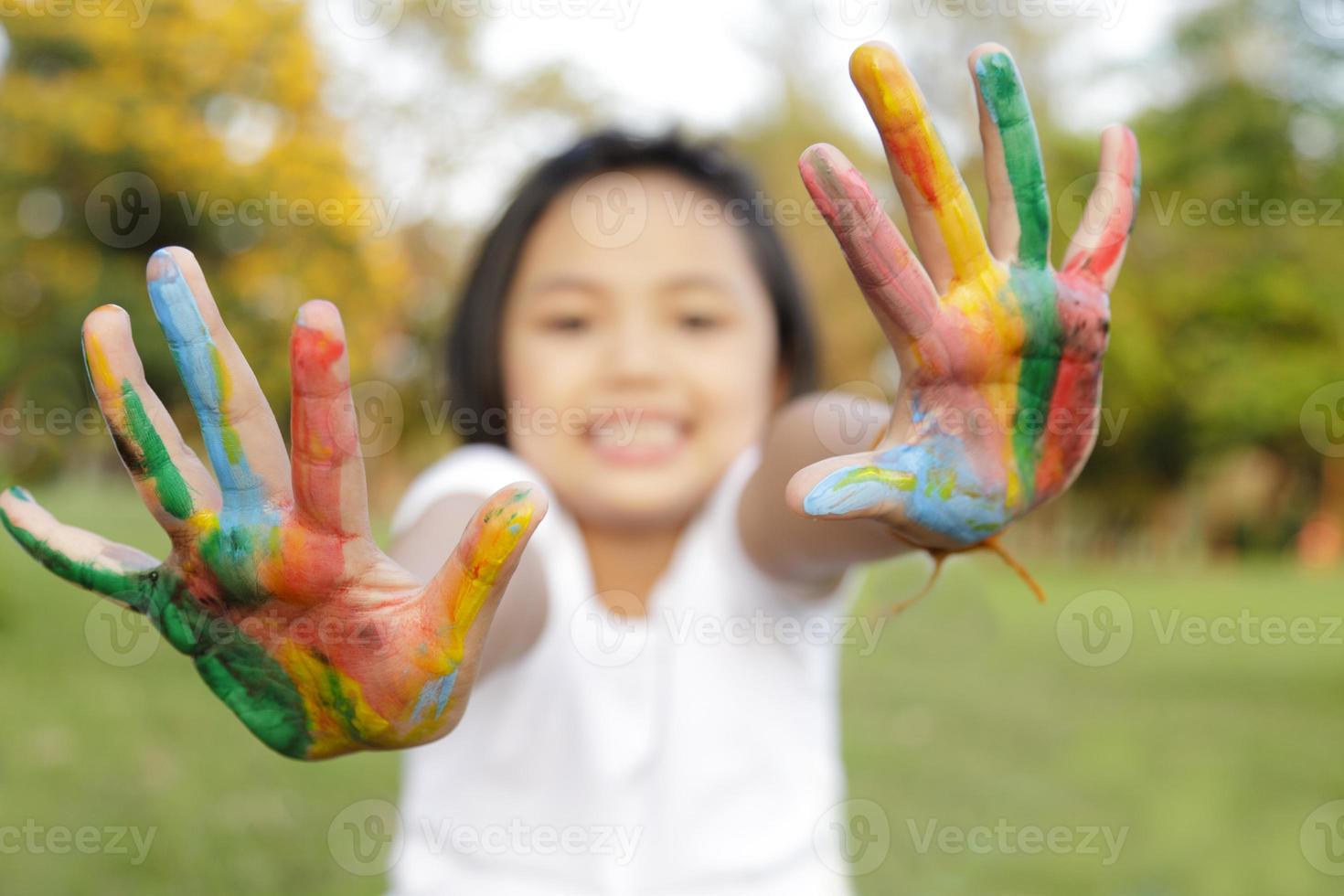 Asian little girl with hands painted in colorful paints photo