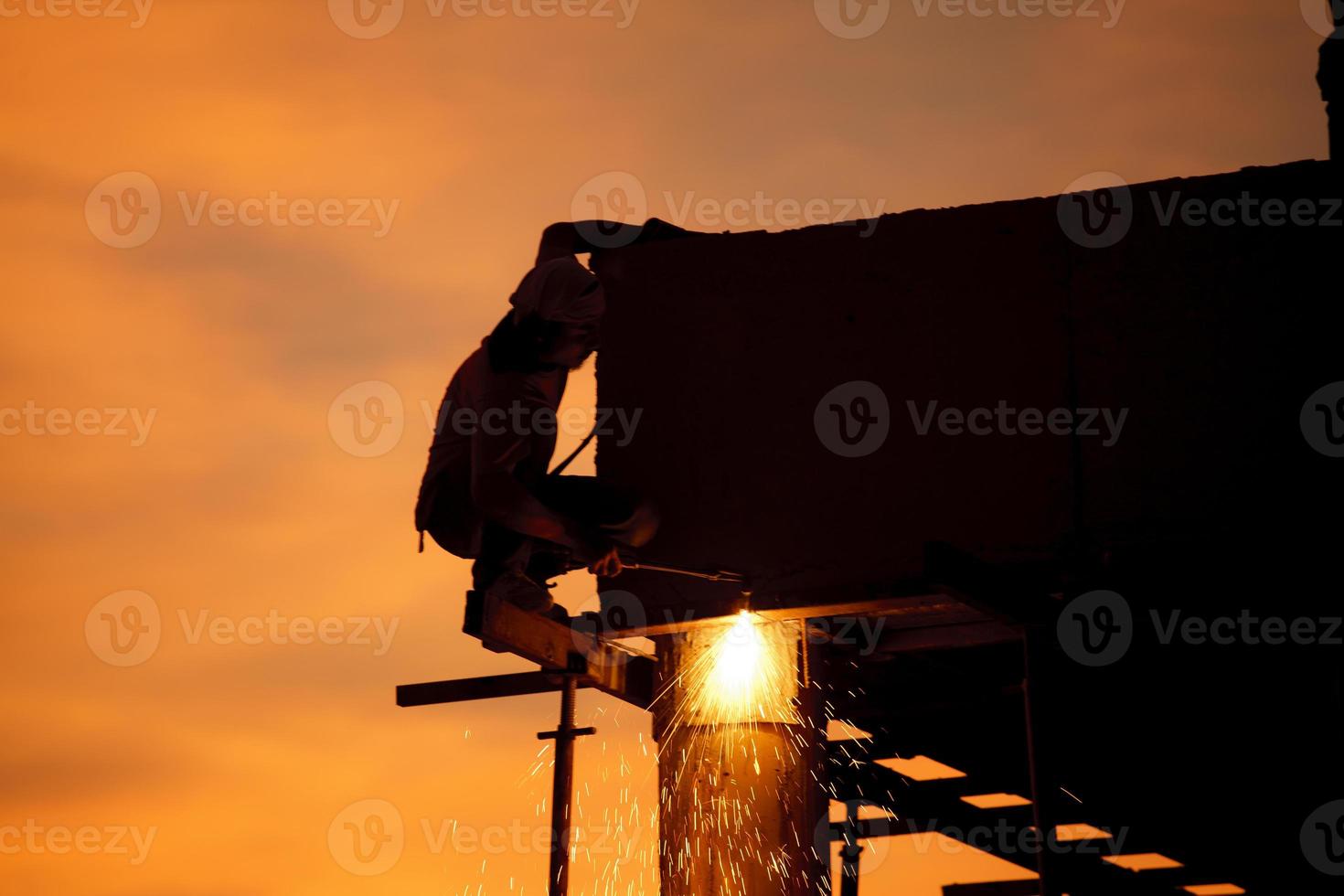 Silhouettes of worker welder photo