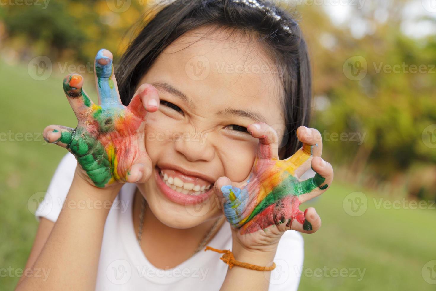 Asian little girl with hands painted in colorful paints photo