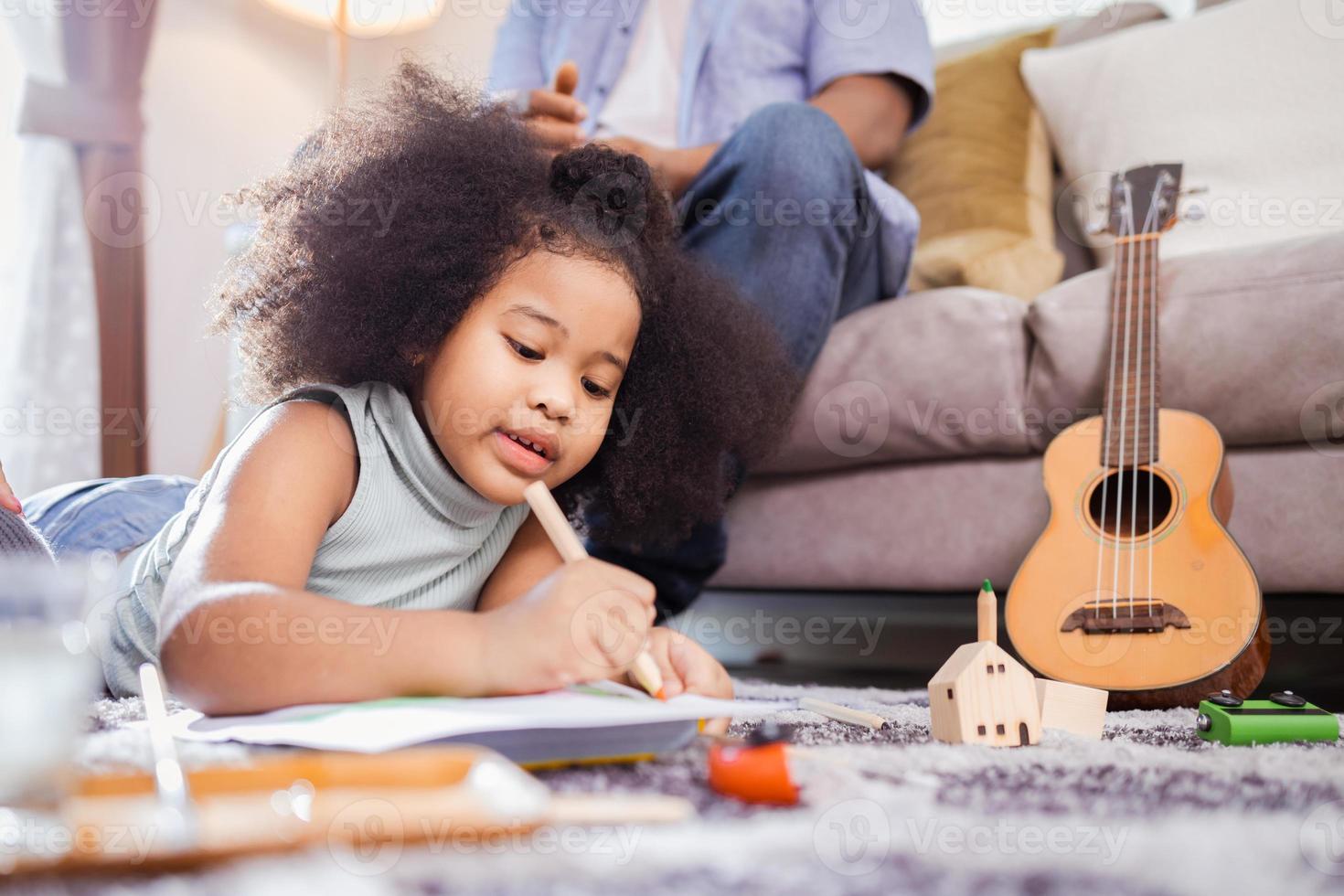 Having Fun At Home. African American kid girl drawing with watercolors in the living room photo