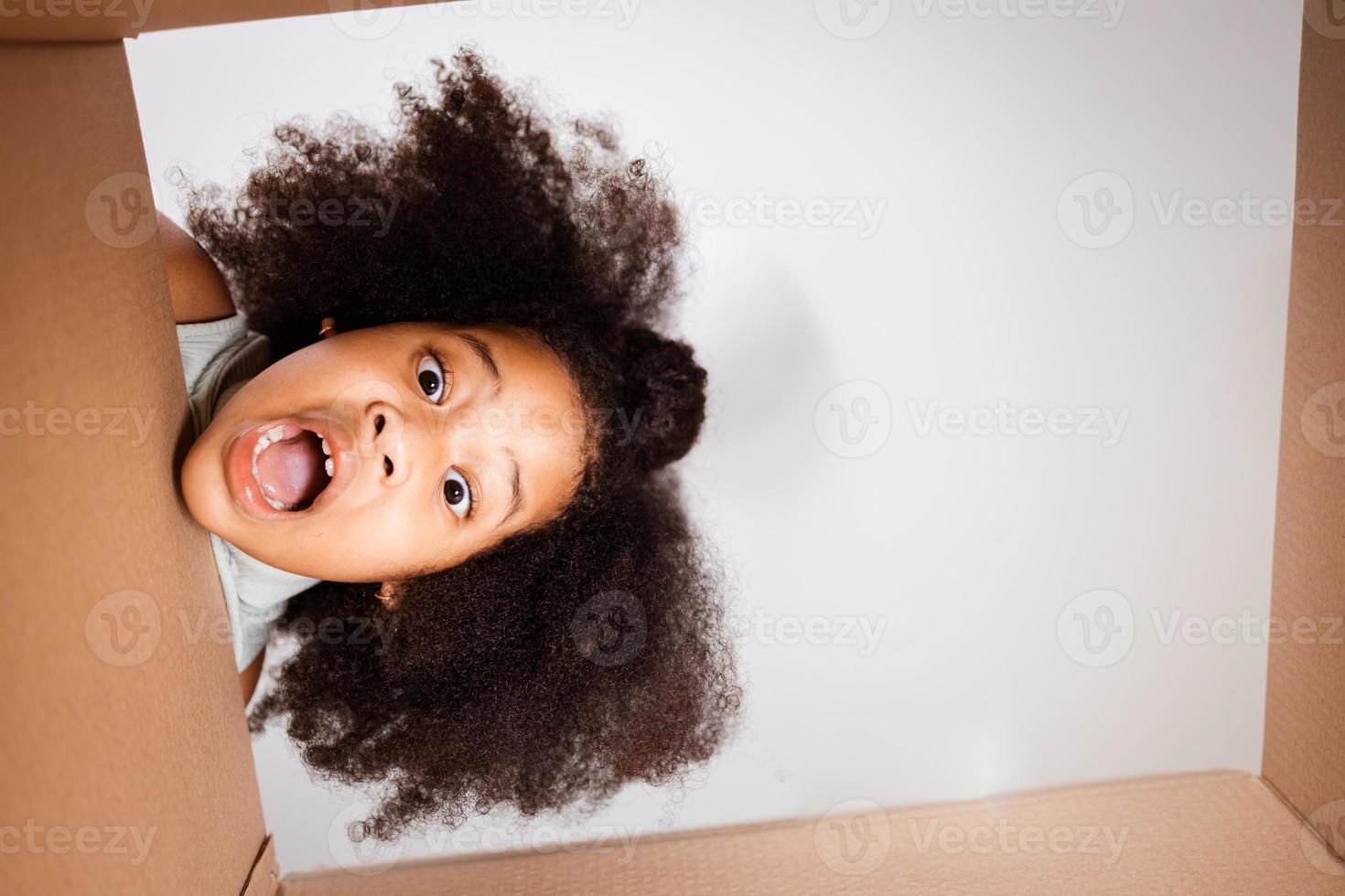 Surprised child unpack big gift box at home photo