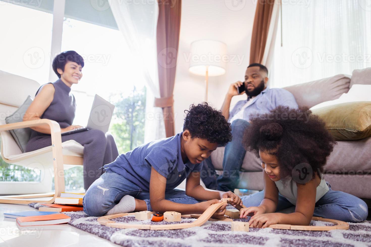 Happy African American family. little boy and girl having fun and play toys in the living room photo