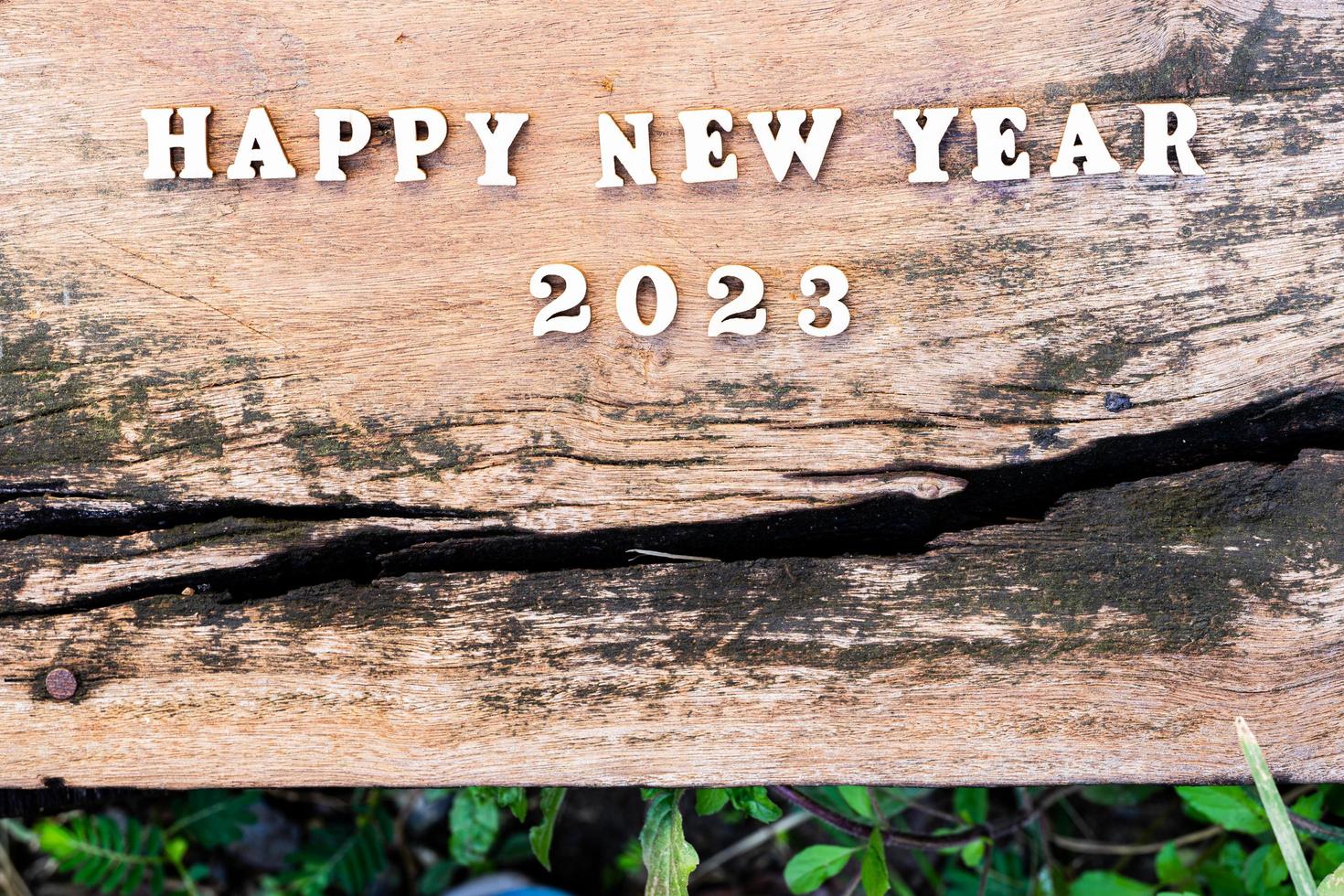 Happy New Year 2023 concept. Wood text on old wooden plank. Empty space. photo