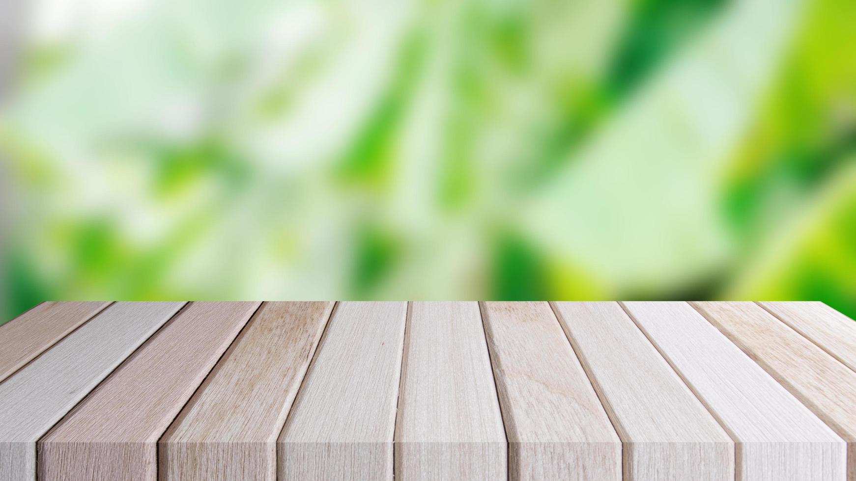 Copy space of blurry green banana leaf tree. Empty desk shelf brown wooden of front. photo