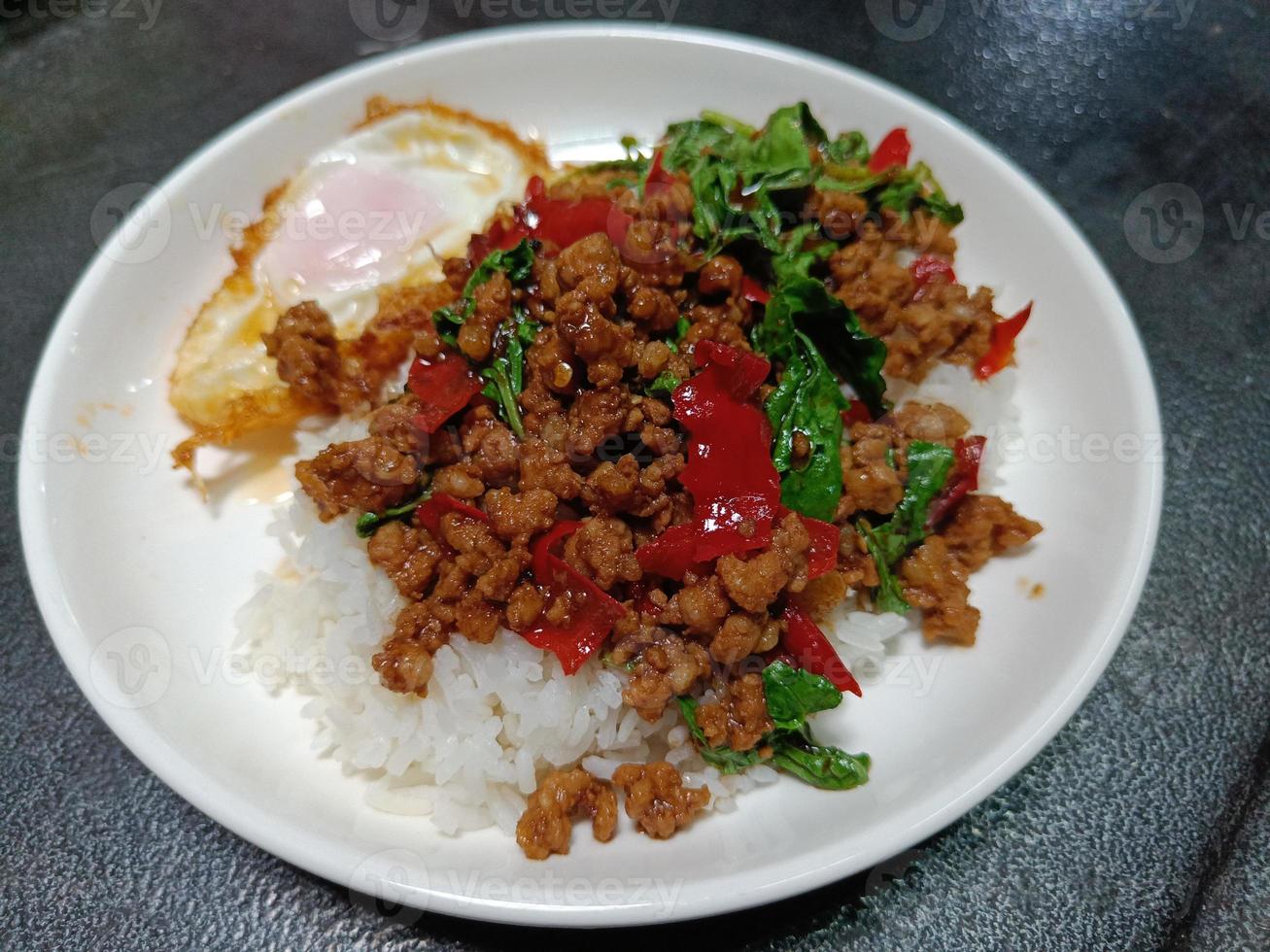 Stir fried minced pork and chili mix with basil on top steamed rice, hot and spicy photo