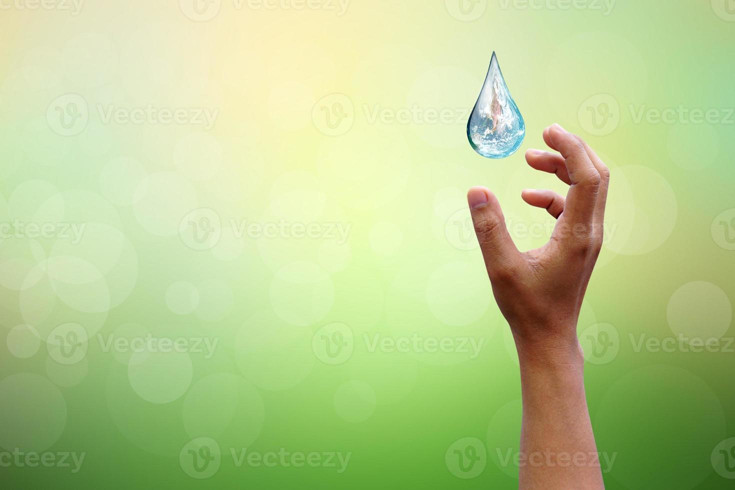 manos del día mundial del agua esperando el mundo en forma de gota de agua en el fondo flores borrosas y cielo con la luz del sol. elementos de esta imagen proporcionada por la nasa. foto