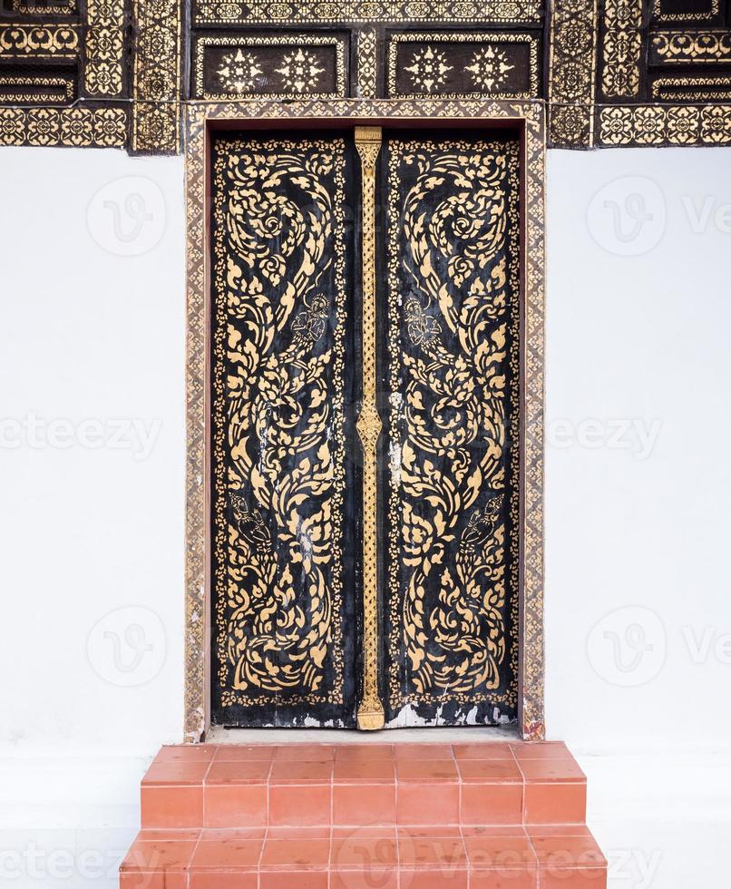 Old wooden door with the traditional Thai pattern. photo