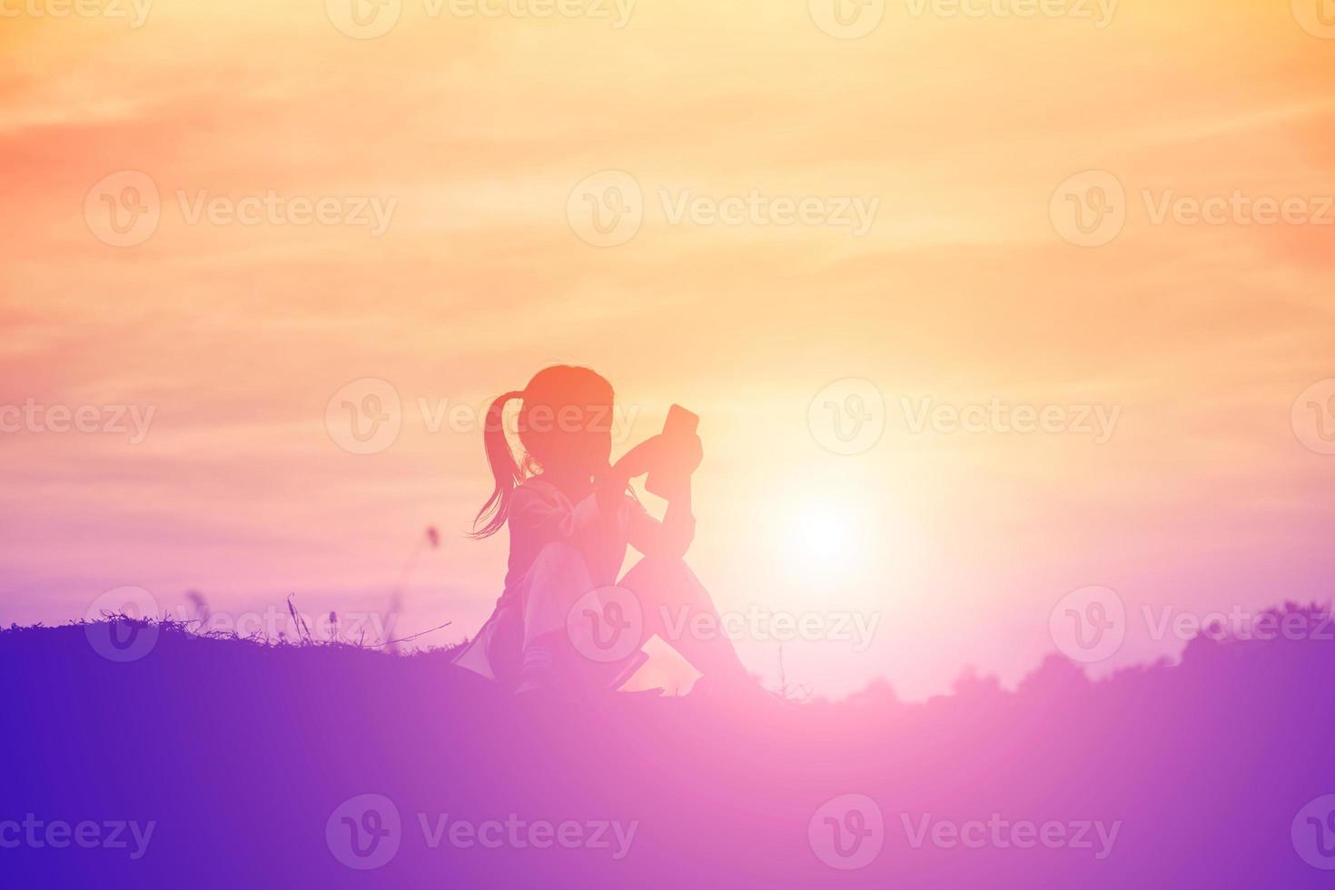silueta de niño, momentos de alegría del niño. en la puesta de sol de la naturaleza foto