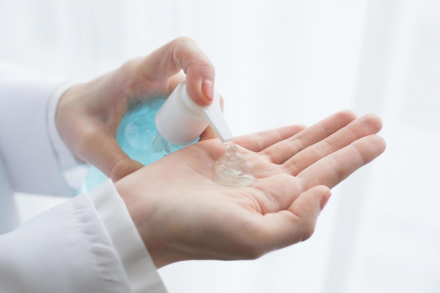 The female doctor sat using alcohol gel to wash her hands while waiting for the disease examination in  health care, new normal and coronavirus protection concept. photo