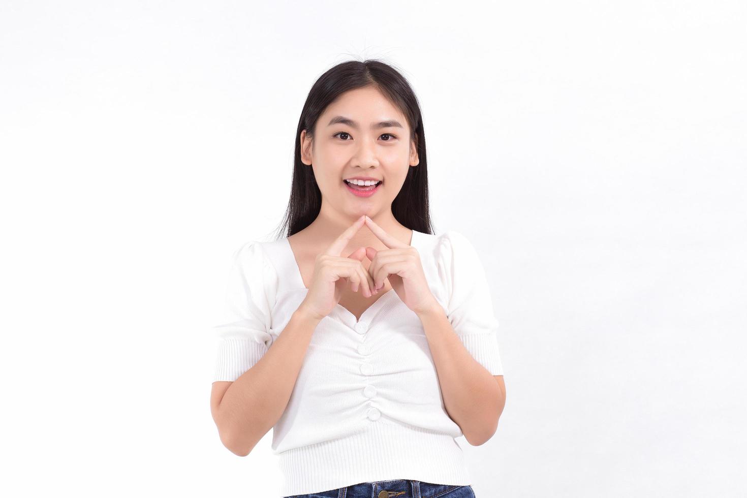 Asian beauty woman standing smiling in pink dress is looking at something while touching her face on a white background. photo