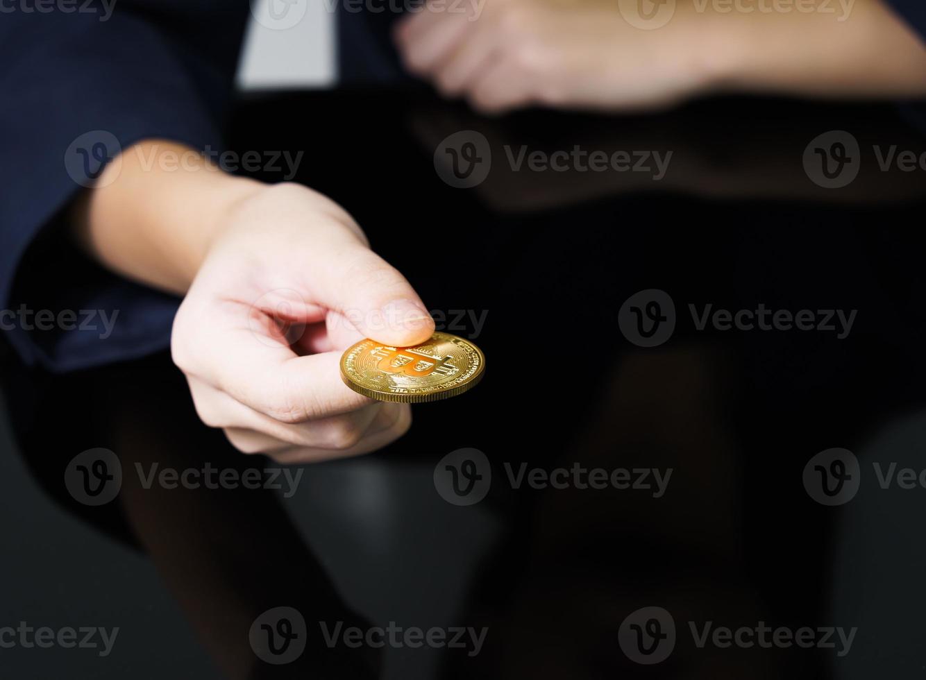 Close up of businesswoman holding some pieces of golden Bitcoin token photo