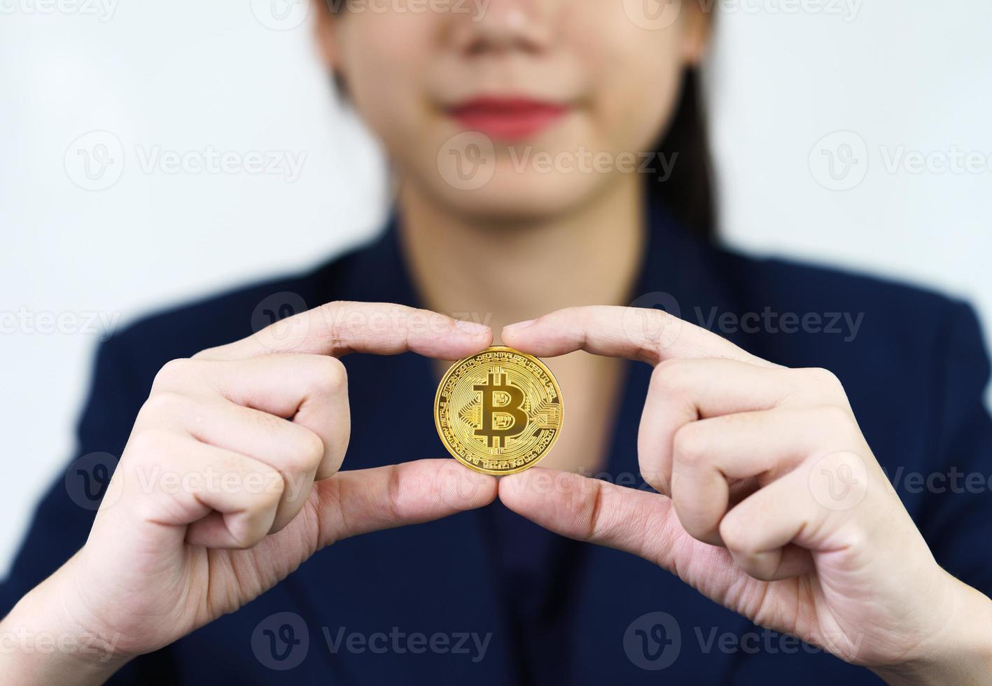 Close up of businesswoman holding some pieces of golden Bitcoin token photo