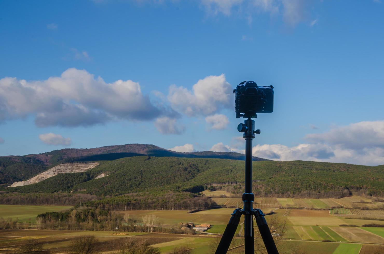 camera with tripod and landscape photo