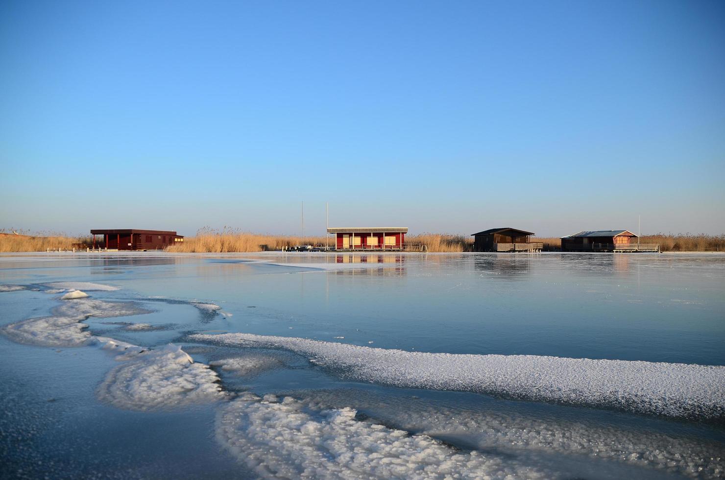 colorful shacks on frozen lake photo