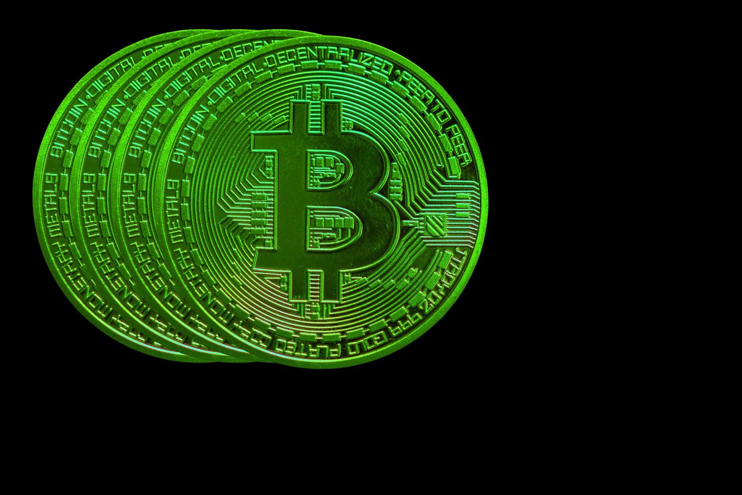 four green bitcoin from crypto currency during rising market on black back photo