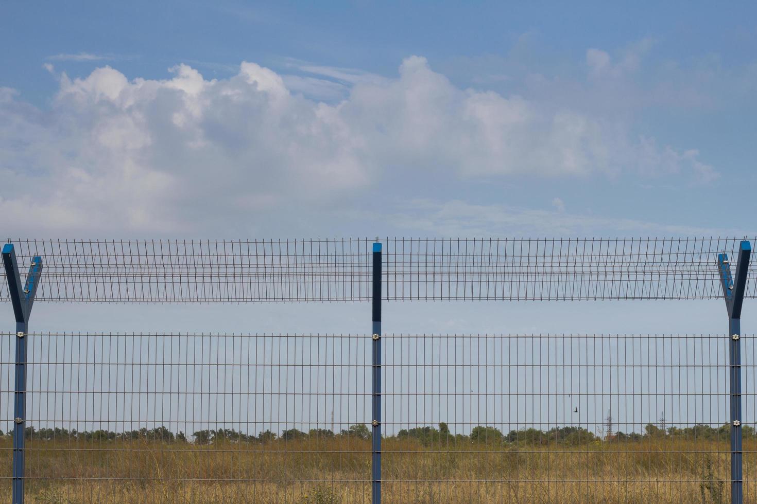 cage fence in fields, blue sky background photo