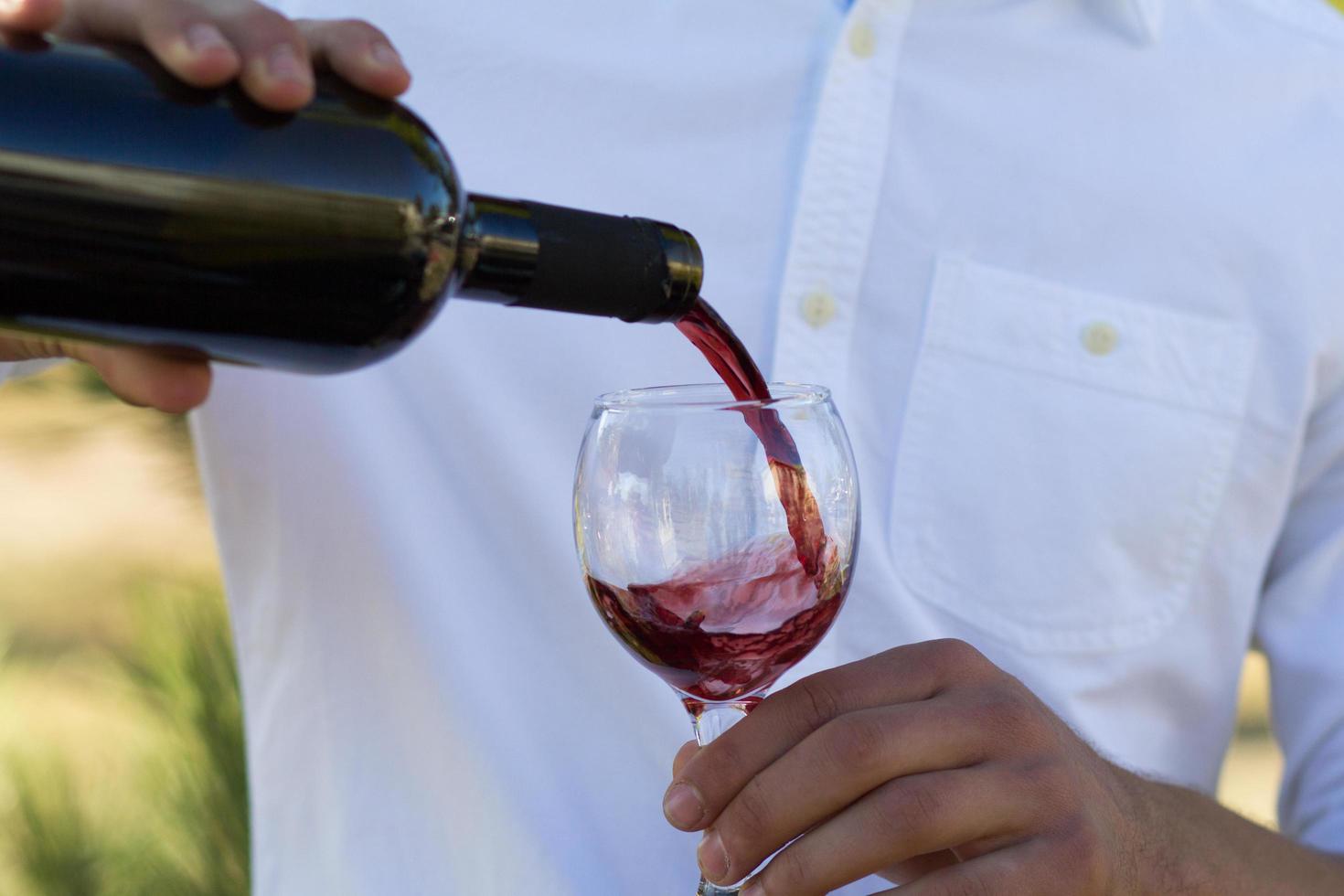 man pouring wine into a glass photo