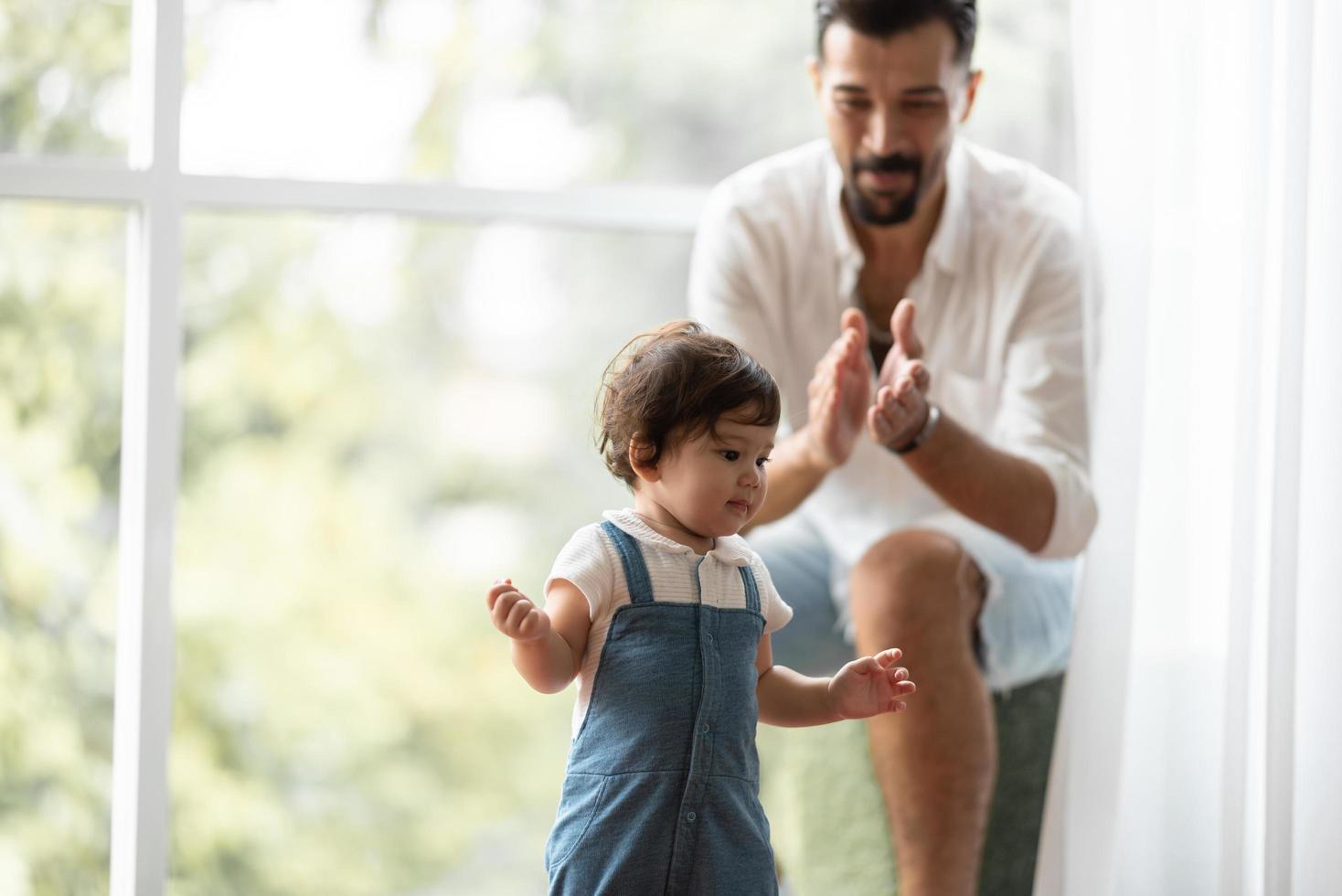 cute toddler little child family concept, baby learning to walk with father and mother to help care and holding hand, first step with childhood parent support, small love portrait little boy at home photo