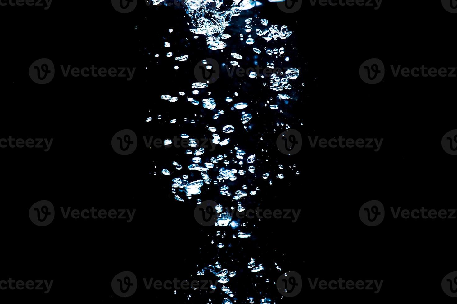 Water bubbles isolated on black background, close up view. Rippling liquid surface, an abstract background for overlays design photo