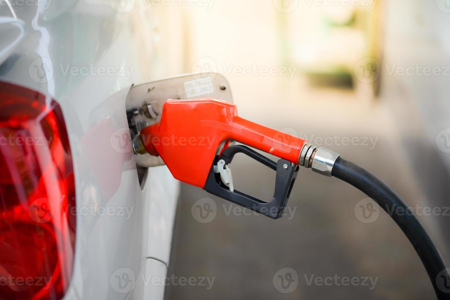 coches aparcados durante el repostaje. inyector de combustible en la bomba de aceite foto