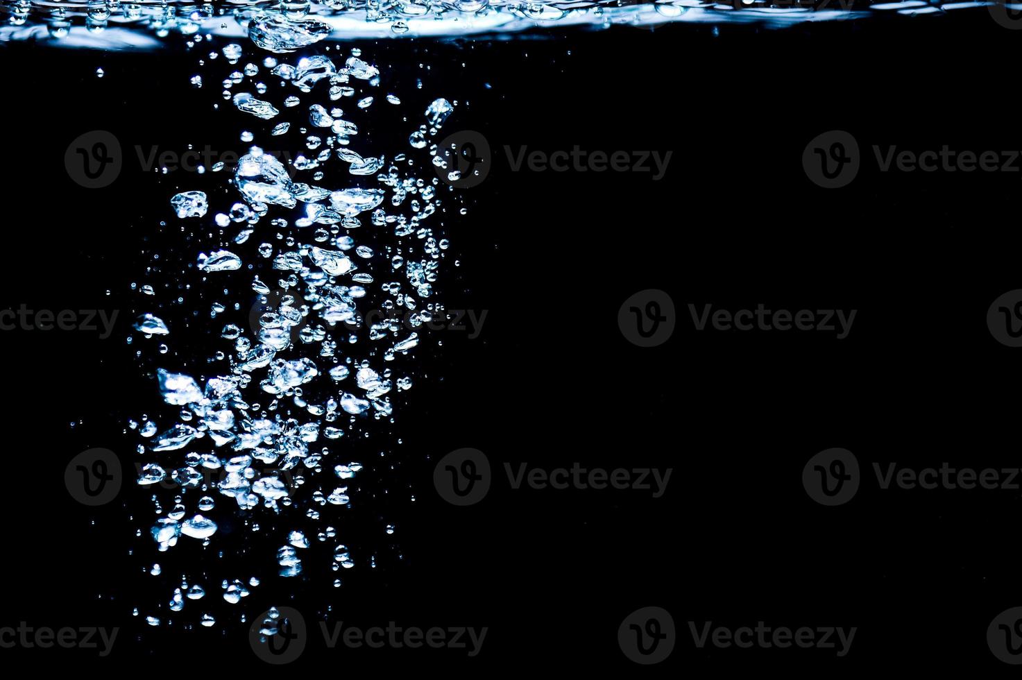 Water bubbles isolated on black background, close up view. Rippling liquid surface, an abstract background for overlays design photo