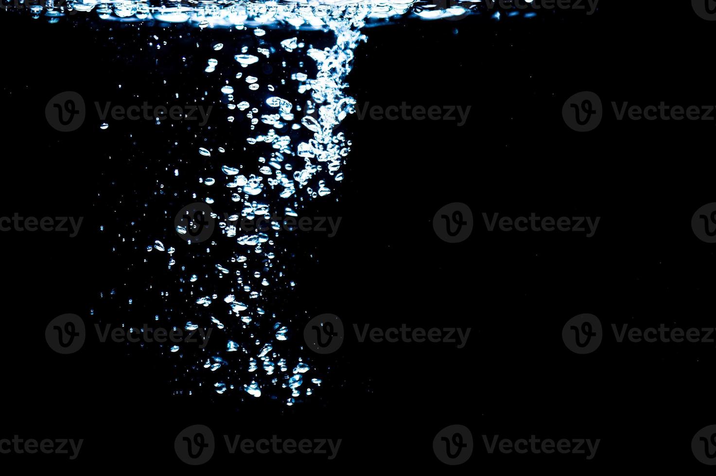 Water bubbles isolated on black background, close up view. Rippling liquid surface, an abstract background for overlays design photo