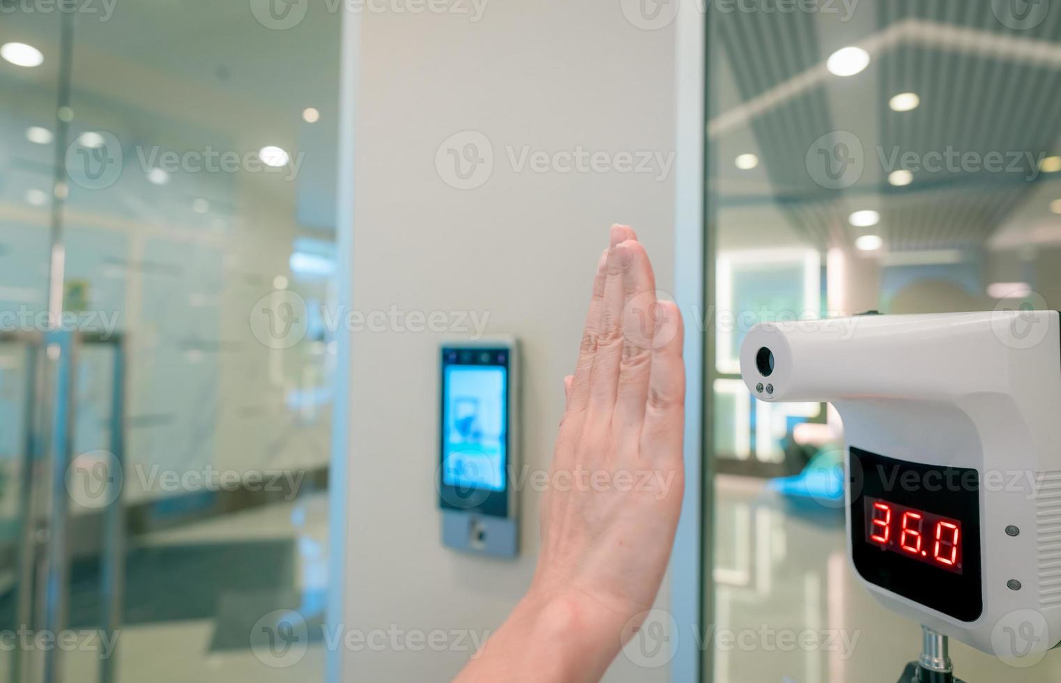 Selective focus on non-contact temperature assessment device. People check body temperature by infrared digital thermometer for screening fever of coronavirus. Palm scan at infrared thermometer. photo