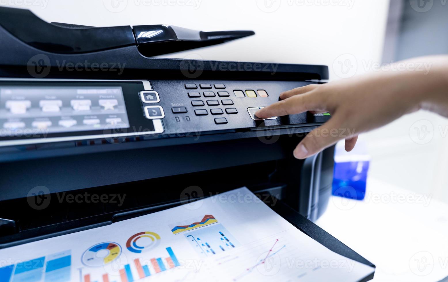 Office worker print paper on multifunction laser printer. Copy, print, scan, and fax machine in office. Modern print technology.  Photocopy machine. Document and paper work. Professional scanner. photo