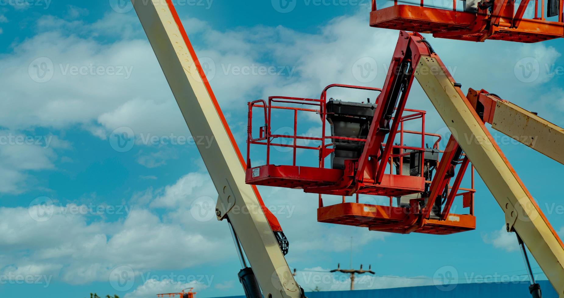 Articulated boom lift. Aerial platform lift. Telescopic boom lift against blue sky. Mobile construction crane for rent. Repair hydraulic boom lift service. Crane dealership. Safety use of machinery. photo