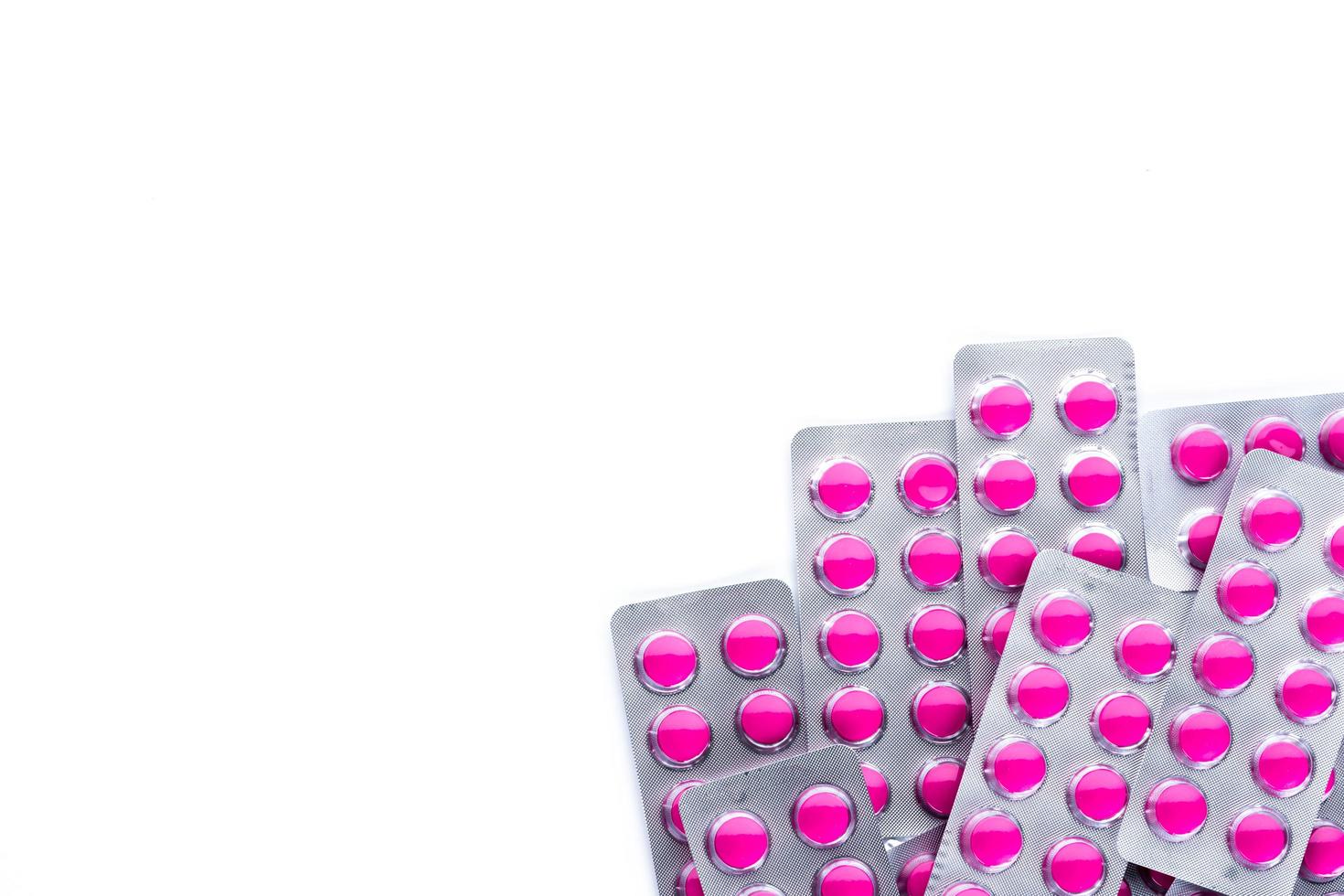 Round pink tablets pills in blister packs on white background with copy space. Ibuprofen tablets pills for relief pain, high fever, headache, toothache and wound inflammation photo