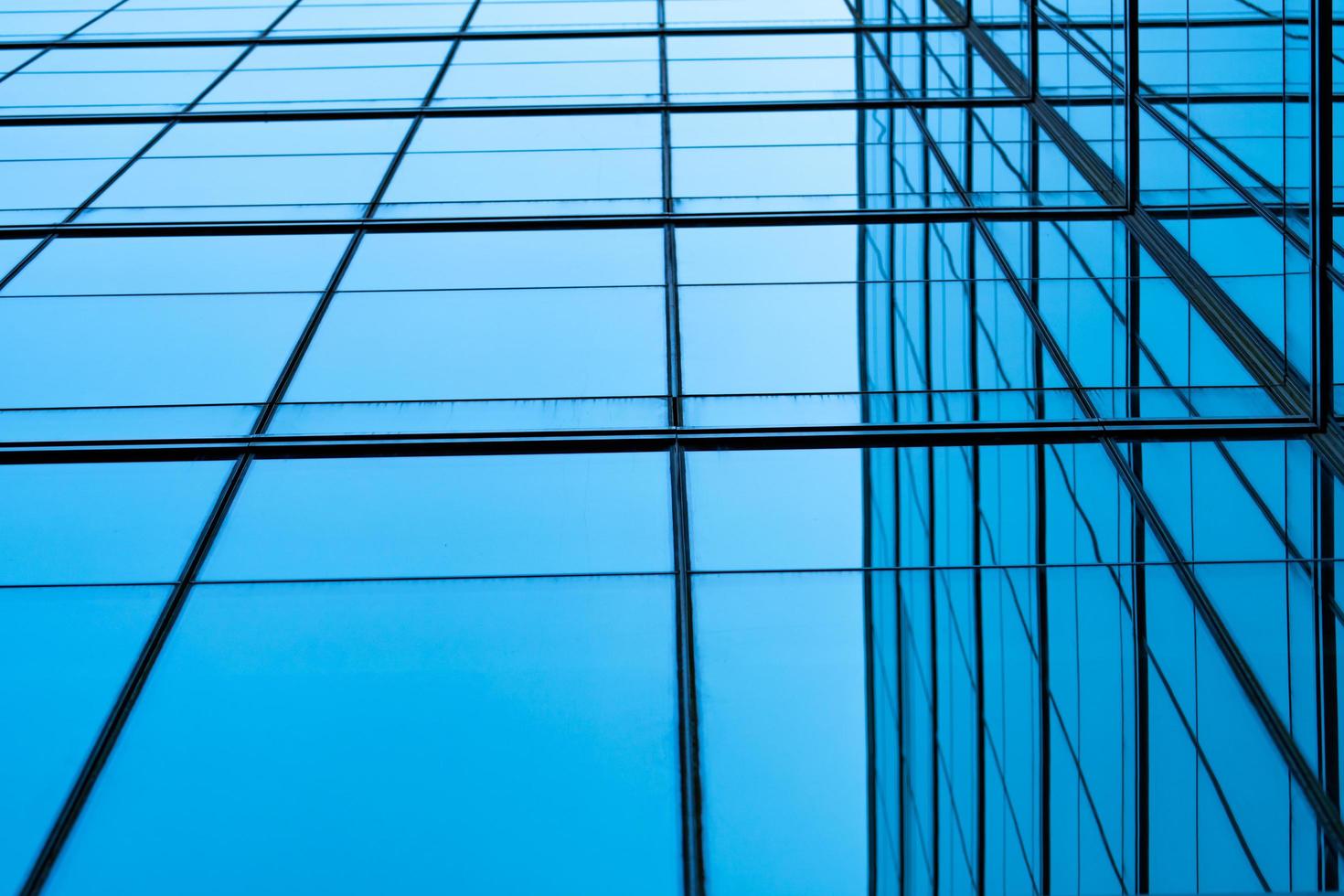 Perspective view of modern futuristic  glass building abstract background. Exterior of office glass building architecture. Reflection in transparent glass of business building. Company glass window. photo