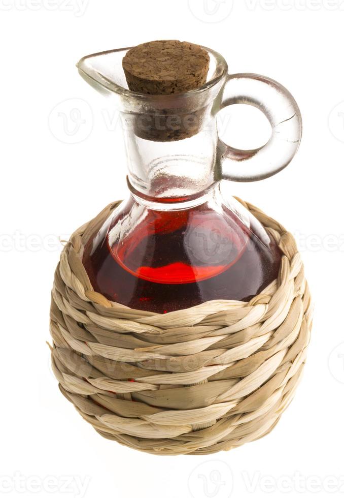 Small decanter with red wine vinegar isolated on the white photo